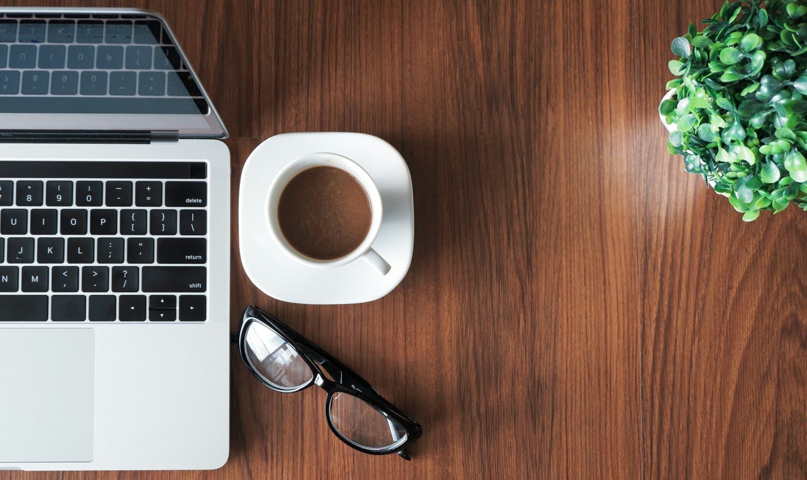 A tidy desk with a laptop and coffee